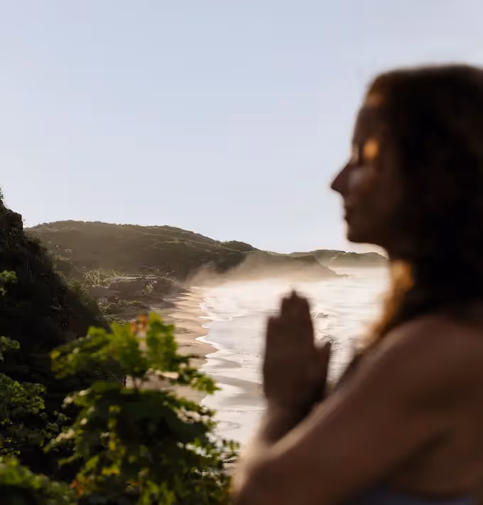Silhouette of a woman meditating with a view of the Pacific Ocean from the terrace of La Valise Mazunte Hotel restaurant.