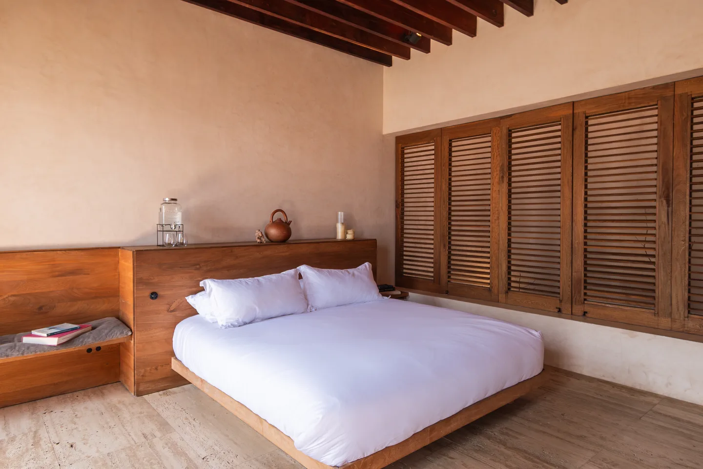 CASA CHICATANA — La Valise Mazunte: King bed on a wooden platform beside a wall of louvred shutters in Master Suite