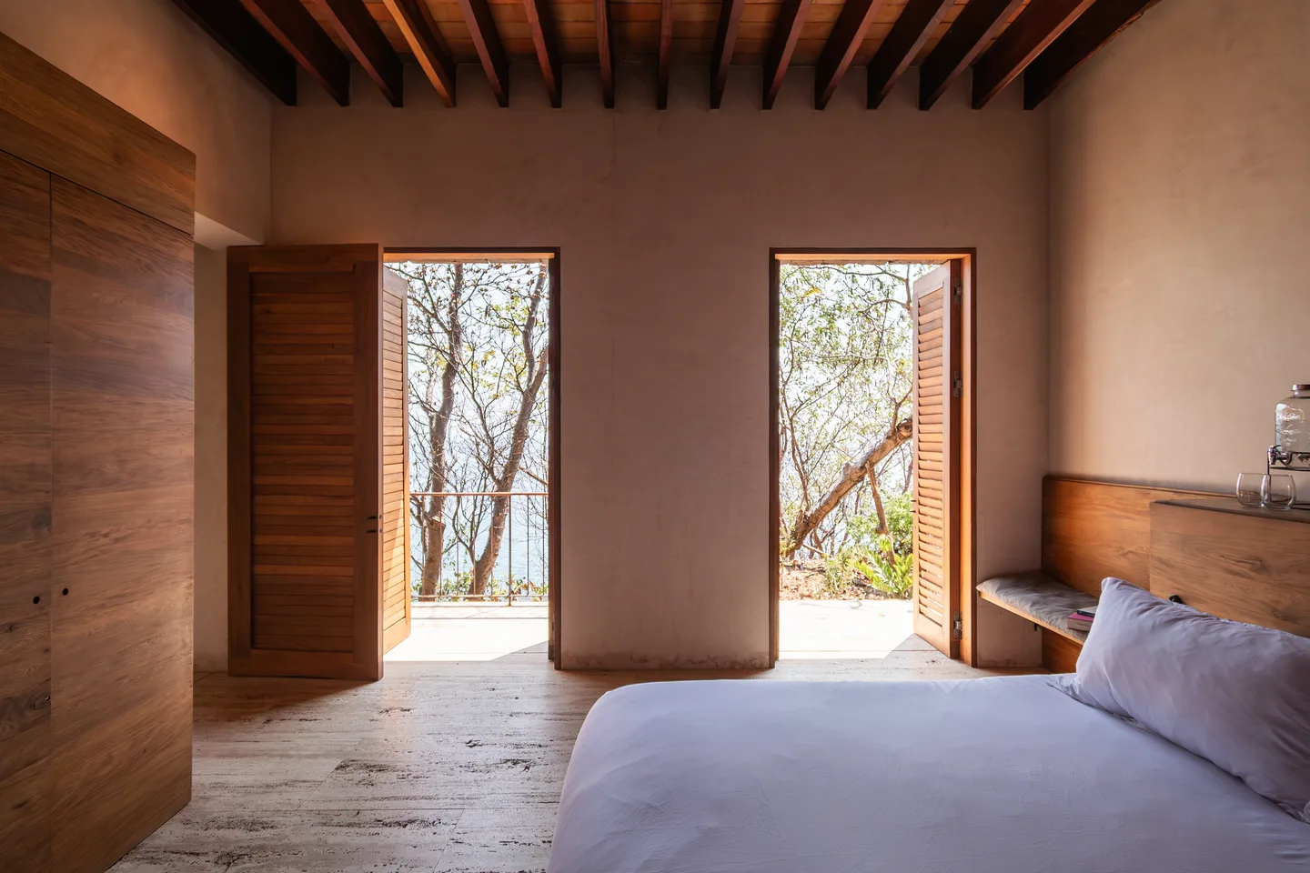 Bedroom of Master Suite Chicatana with two tall doors opening toward the ocean — La Valise Mazunte