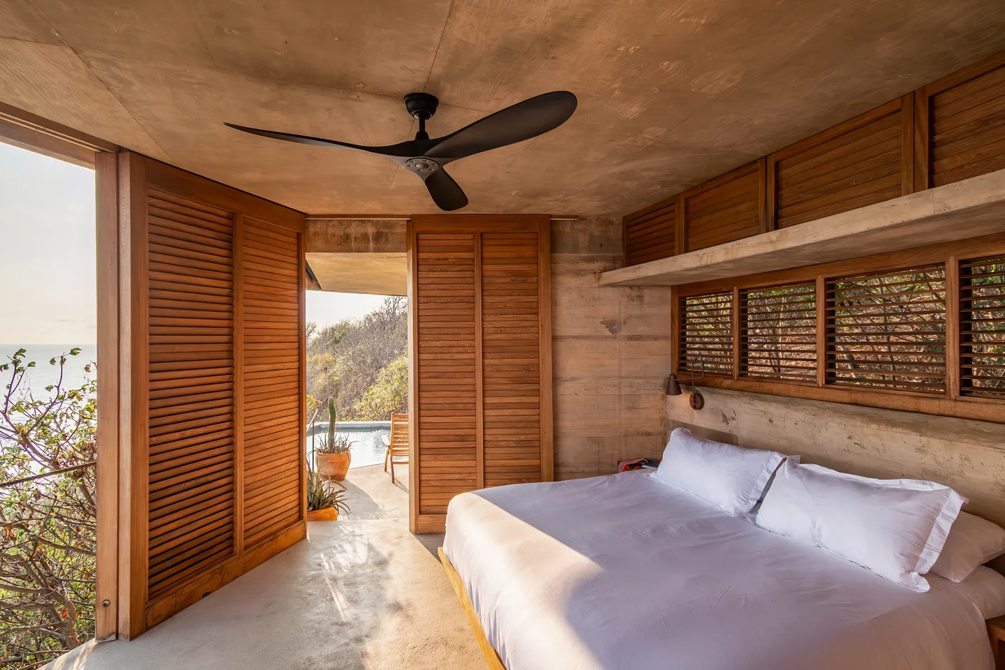 King bed in Villa Pentágonos with wooden shutters open to the Pacific — La Valise Mazunte