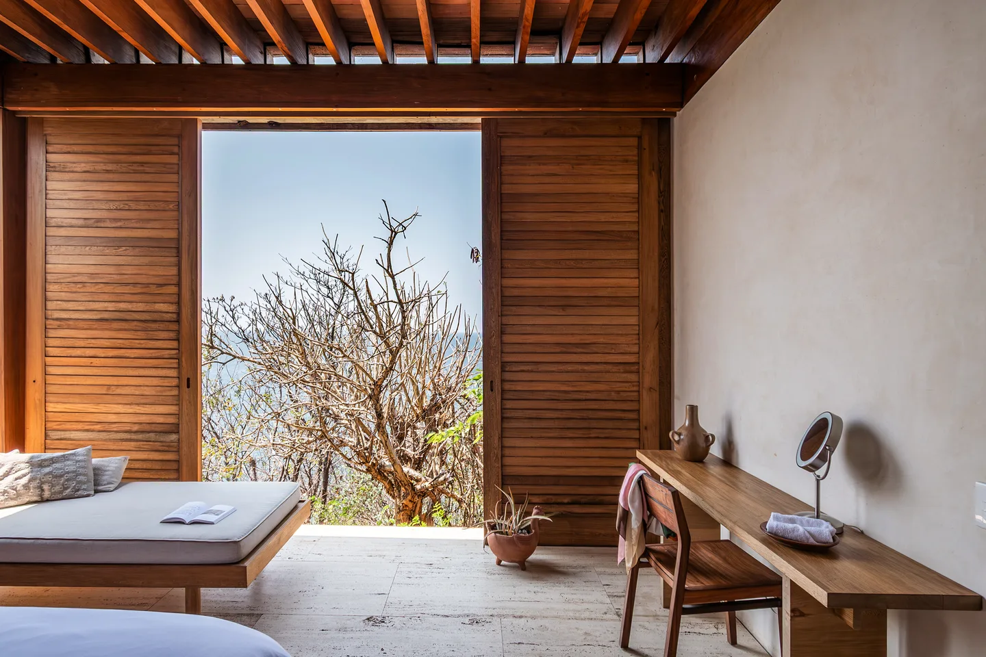 Desk and daybed in Suite Copal beside doors open to nature — La Valise Mazunte