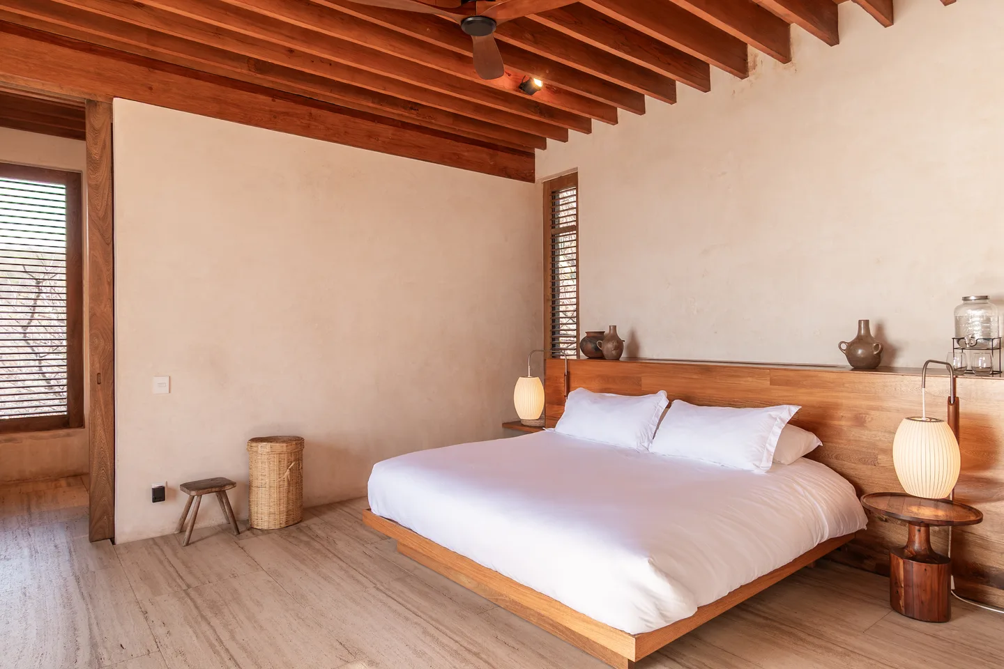 Cama king con mesitas iluminadas por faroles en Suite Guayacán — La Valise Mazunte