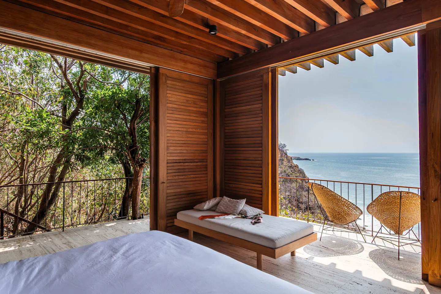Bed in Suite Persianas looking across the daybed and terrace to the ocean — La Valise Mazunte