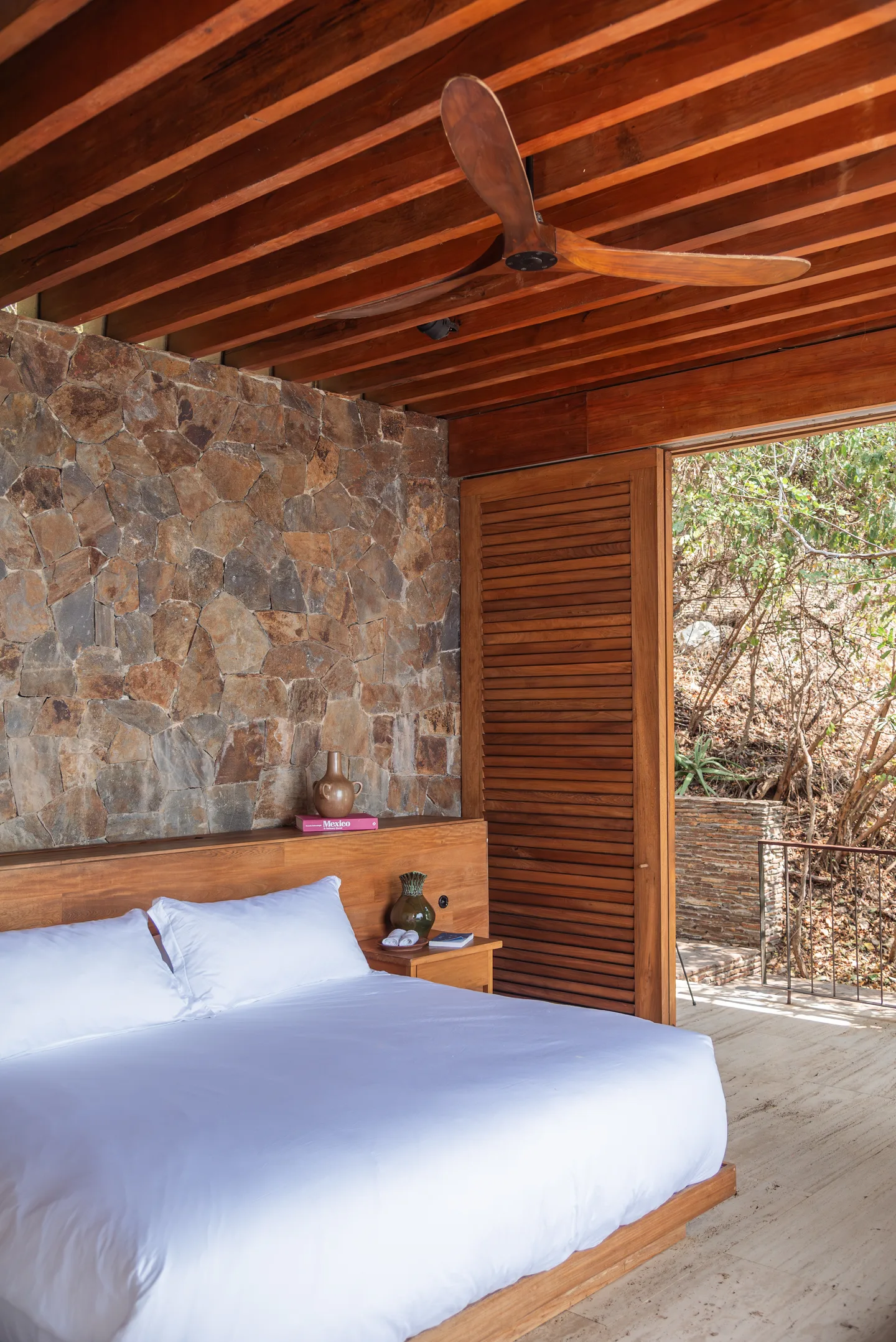 Cama king junto a la terraza abierta en Suite Persianas — La Valise Mazunte