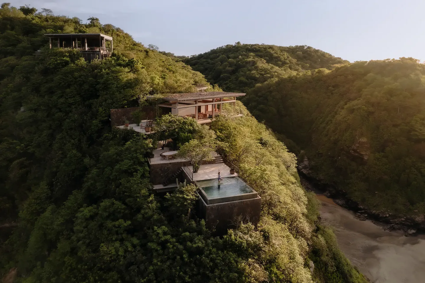 Aerial view of La Valise Mazunte’s casas stepping down a jungle-covered hillside to the beach