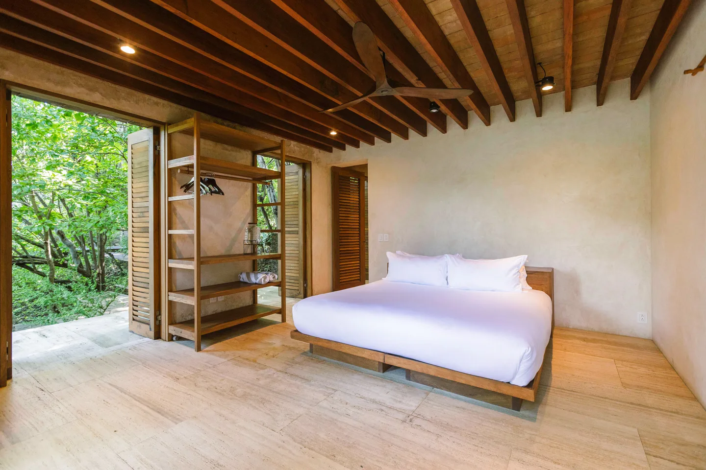 Suite Selva bedroom with open wardrobe and doors to the garden — La Valise Mazunte